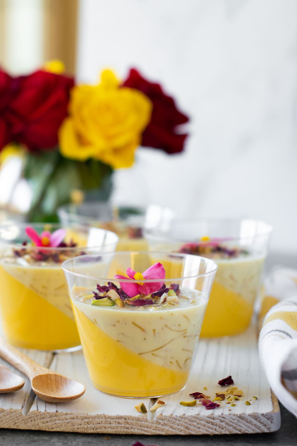 Mango Panna Cotta Seviyaan Kheer layered in a clear glass and garnished with nuts.