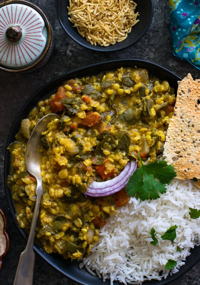 Dal rice on a black plate with bhujia sev