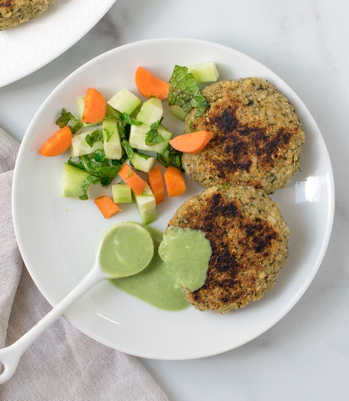 Quinoa paneer kababs with green dip on a white plate