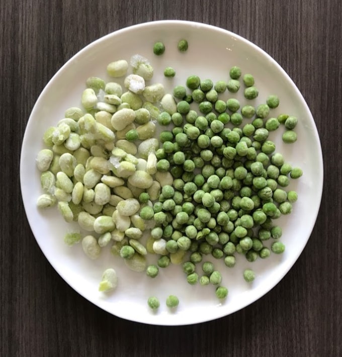 Frozen edammame and peas on a white plate