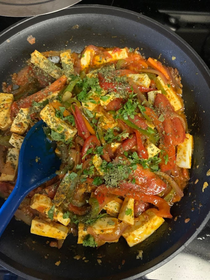 Paneer and veggies mixed together in a pan