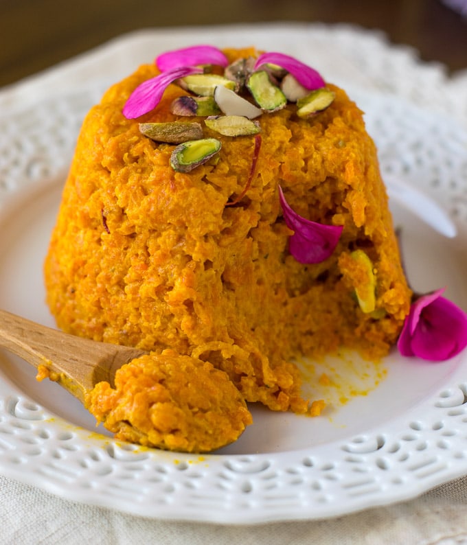 Gajar halwa garnish with flowers and eaten with a spoon 