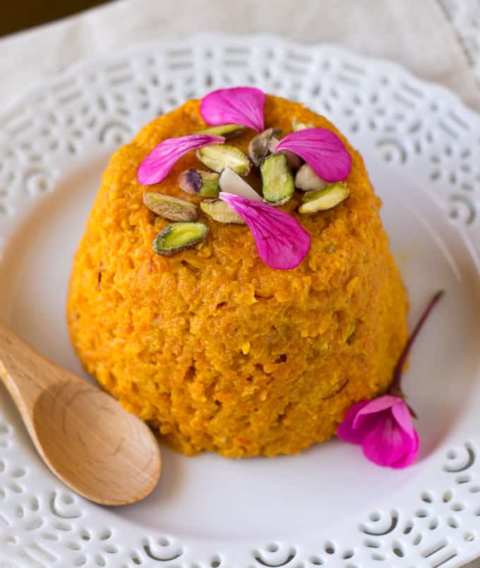 Carrot halva served on a white plate with nuts