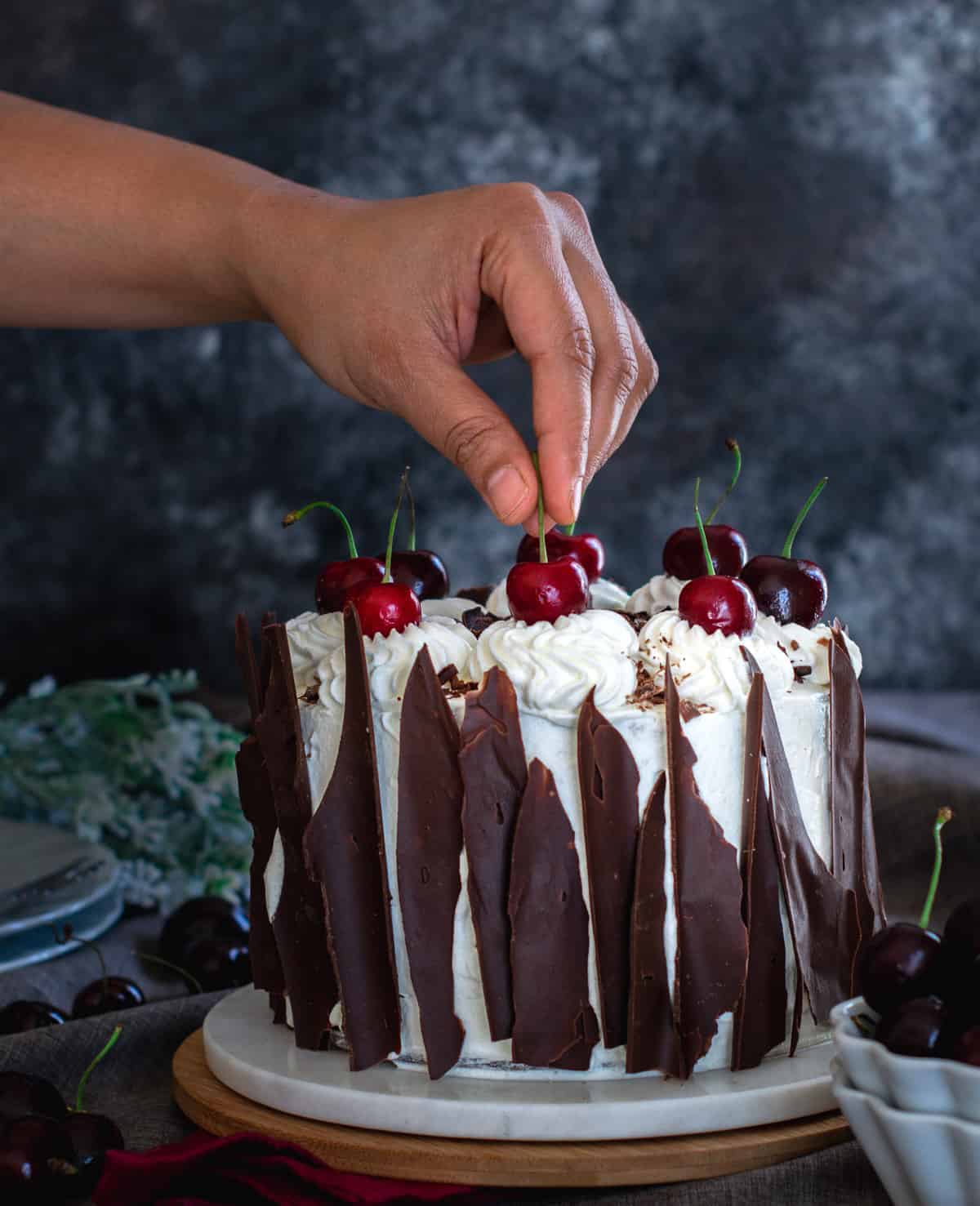 Placing cherries on the black forest cake 