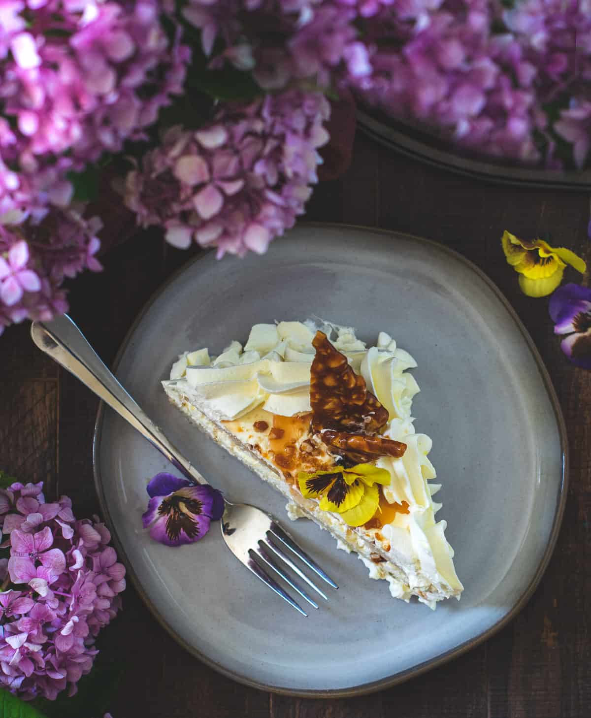 Cake slice on the plate surrounded with flowers