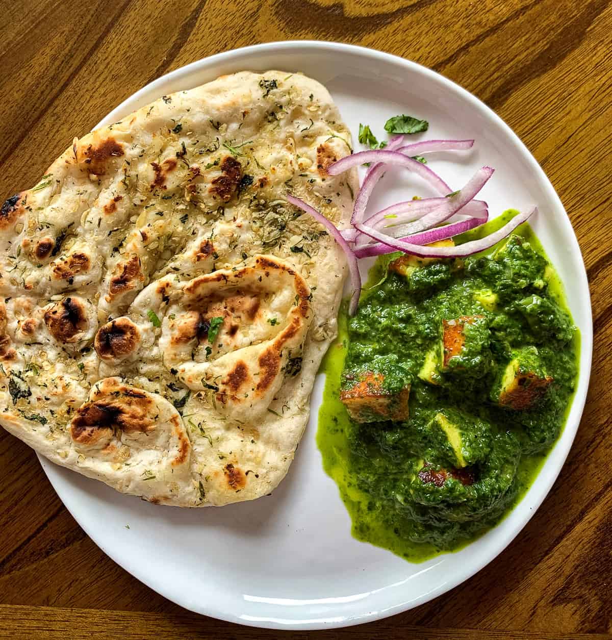 Saag paneer served with naan and onion