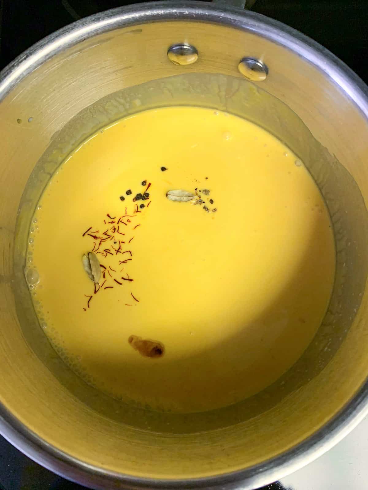 Adding mango puree and cream to the pot