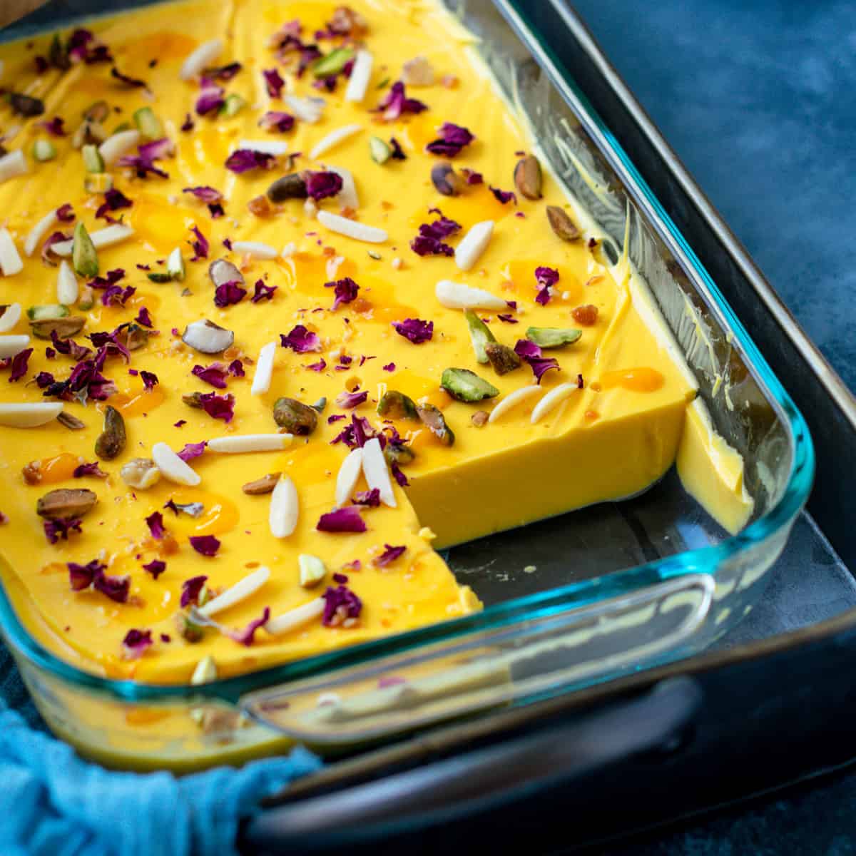 Mango Panna Cotta Without Gelatin set in a glass pan topped with nuts 