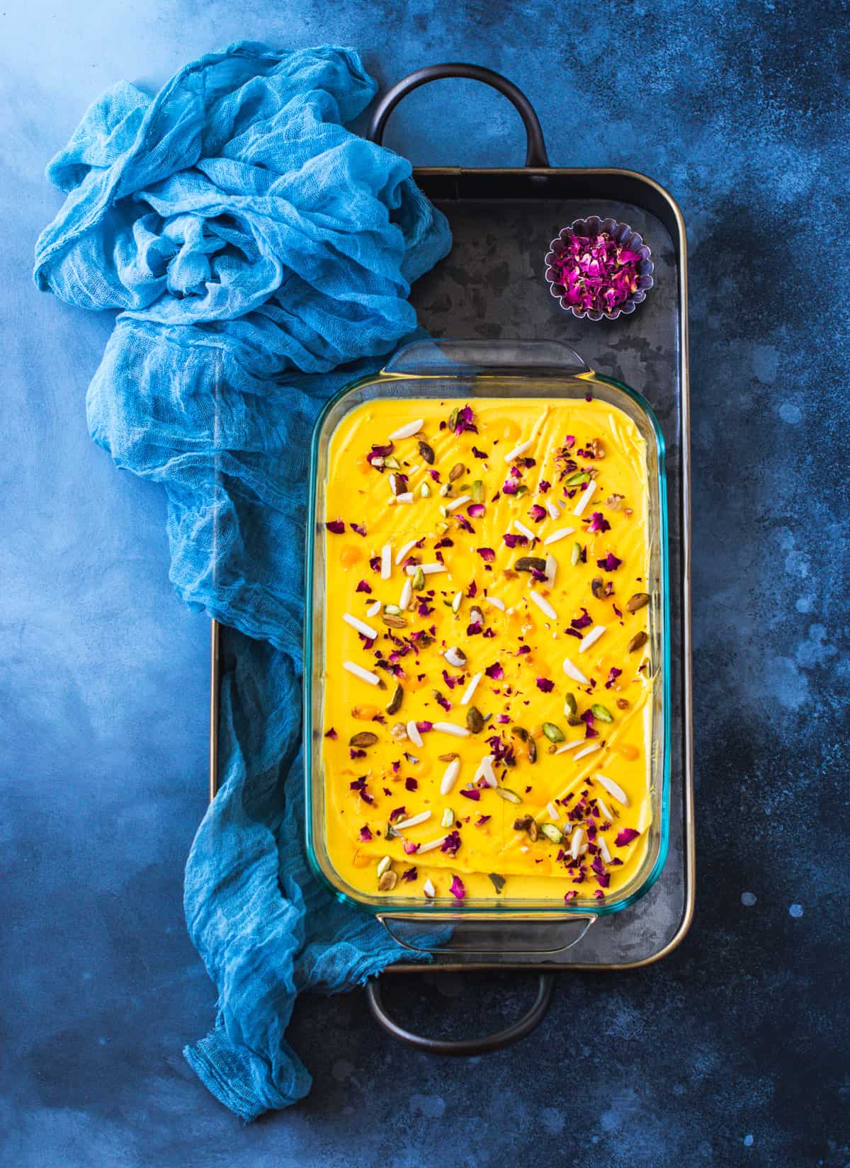 Mango Panna COtta served in a tray with blue cloth on the side