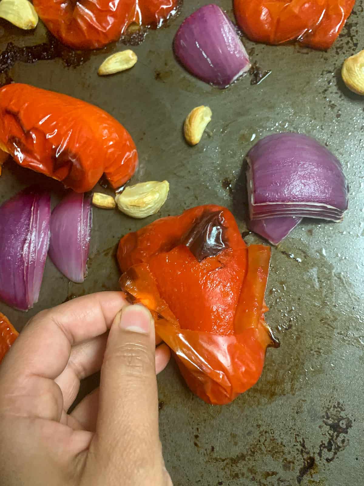 Peeling off the skin of roasted peppers
