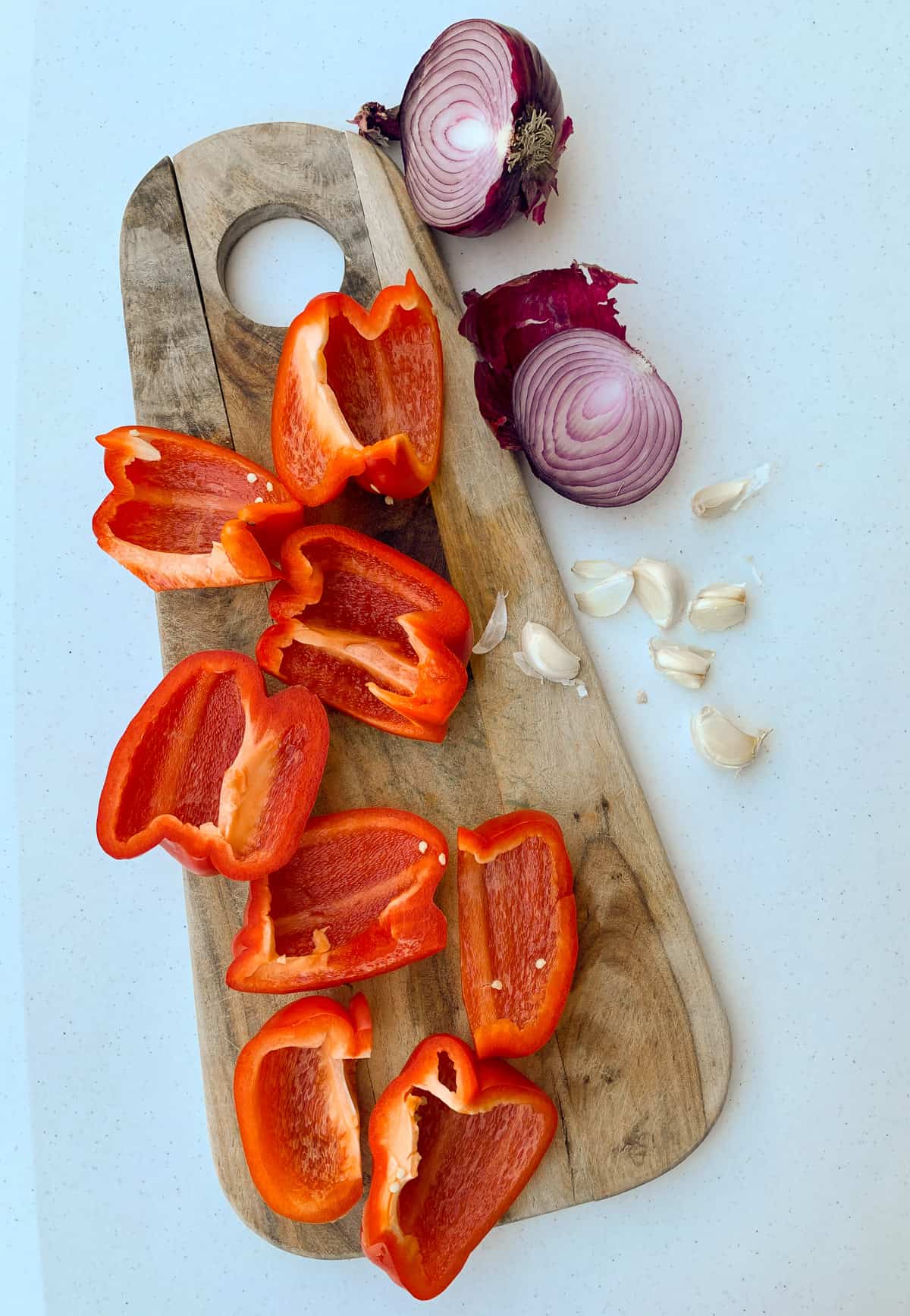 Onions, red bell pepper and garlic on a cutting board 