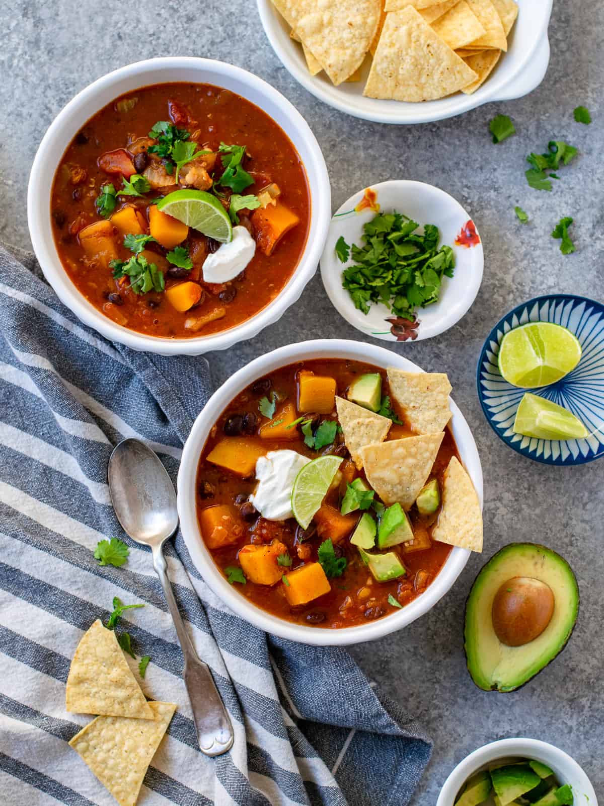 Vegan Butternut Squash and Black Bean Chili served with avocados, sour cream and lemon