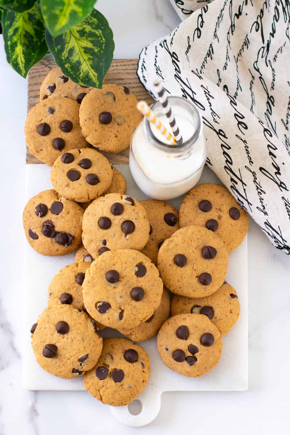 Eggless Whole wheat chocolate chip cookies on a white platter served with milk