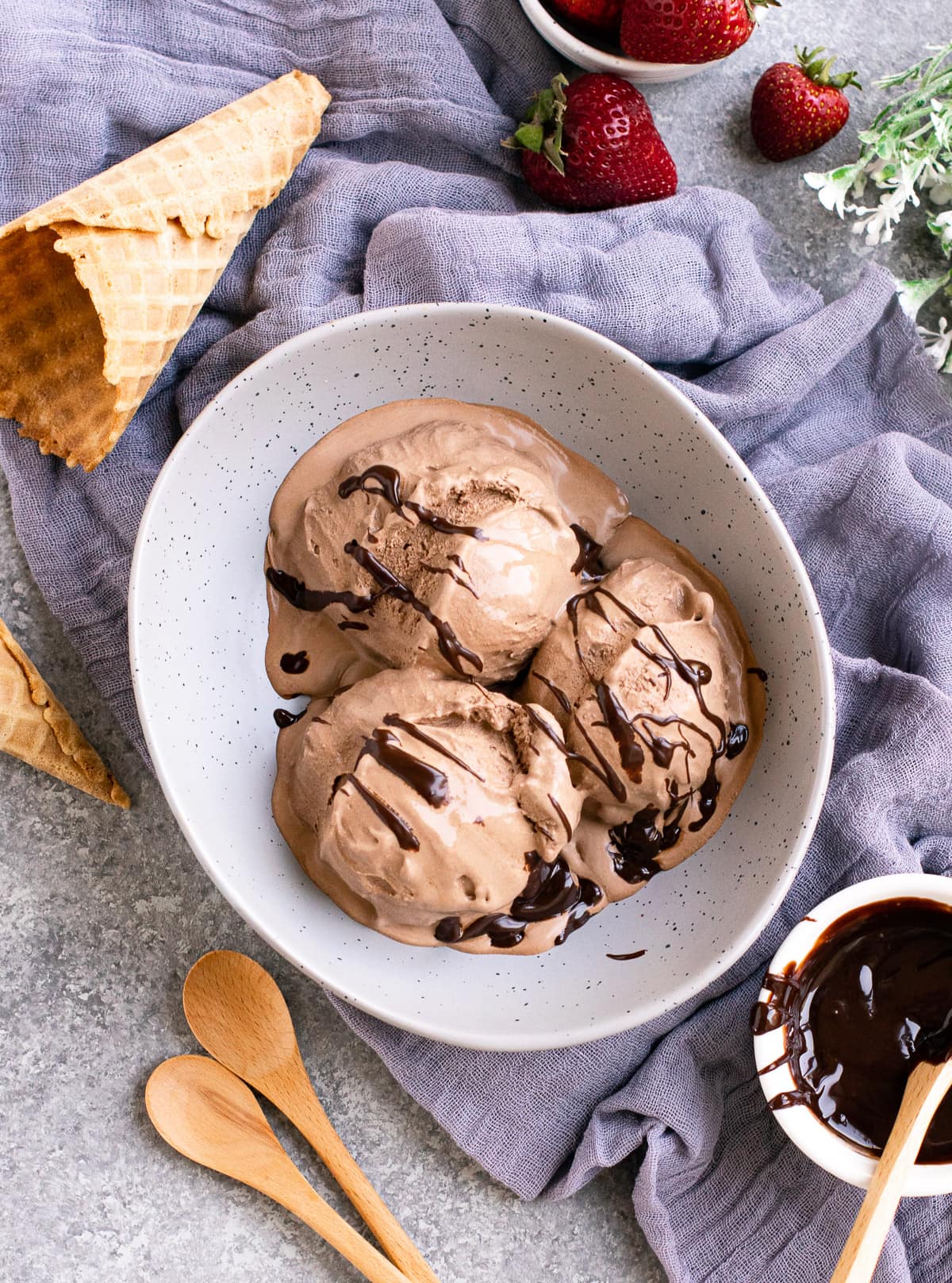 Chocolate ice cream served in a grey bowl with cone on the side