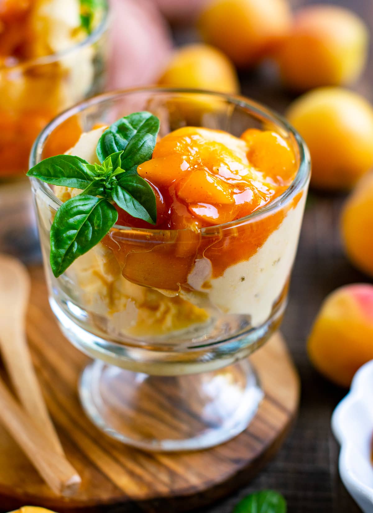Homemade apricot ice cream served in a cup with basil
