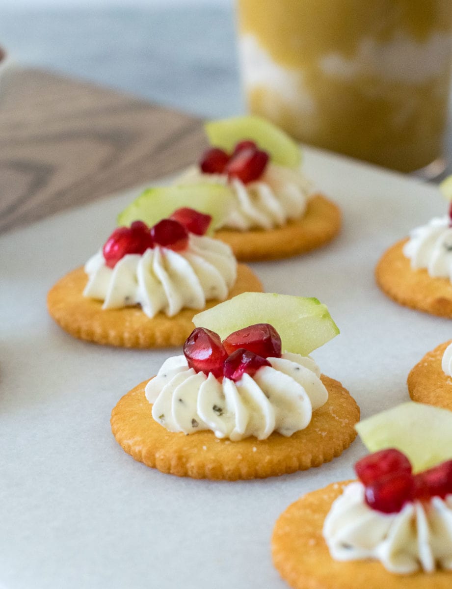 cream cheese over Ritz crackers with cucumber and pomegranate.