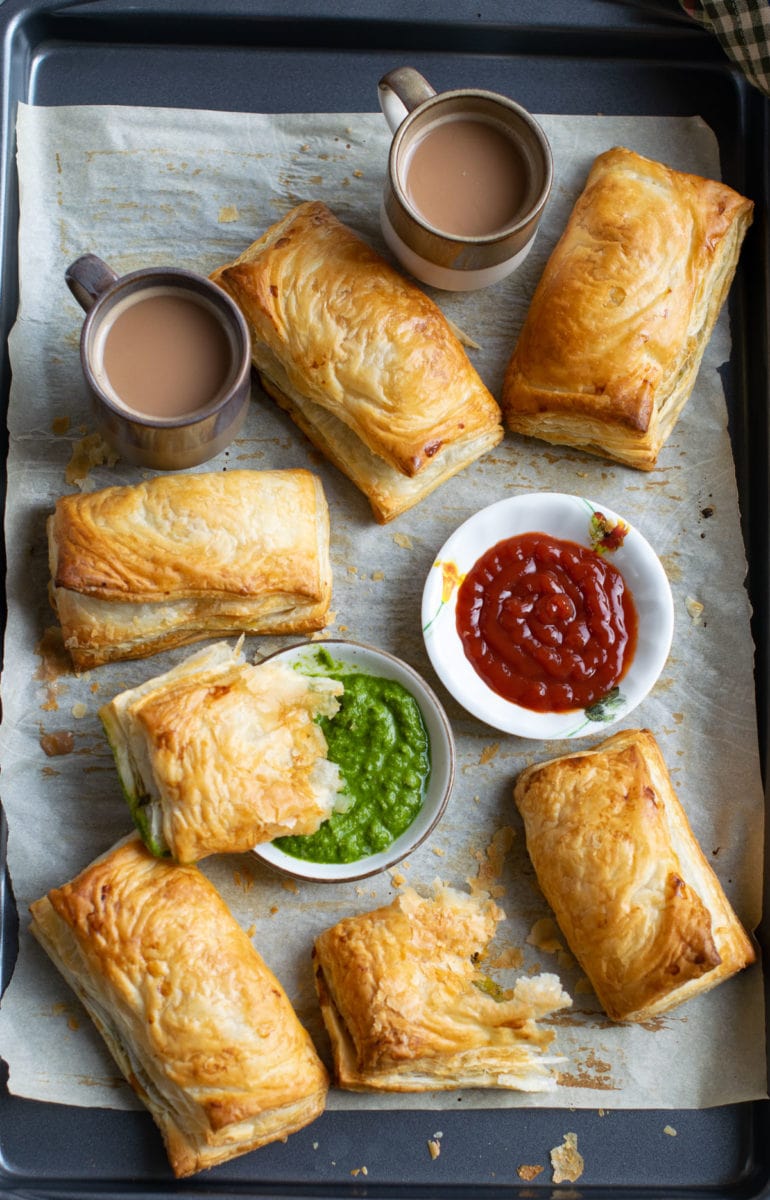 Veg puff served on a tray with ketchup and chutney. 