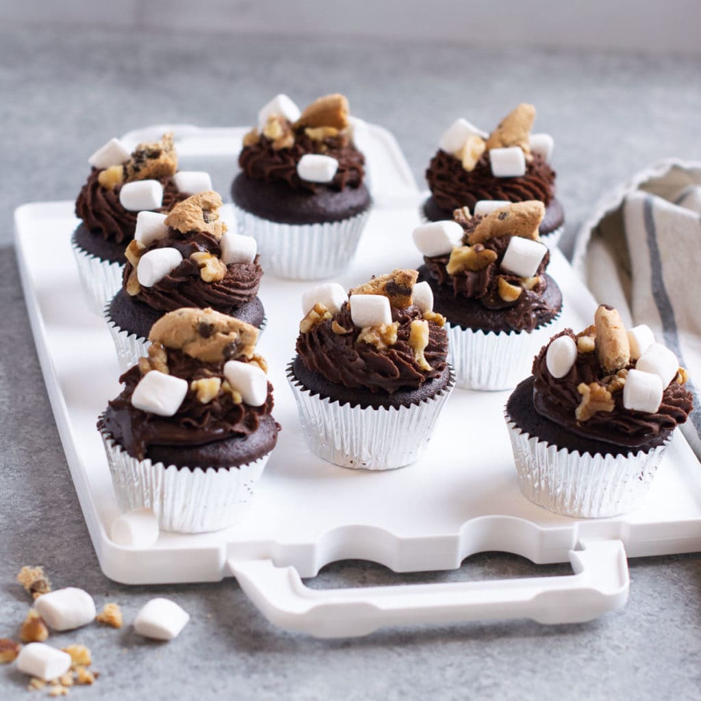 Chocolate cupcakes piped with ganache and topped with cookies, walnuts and marshmallows.  