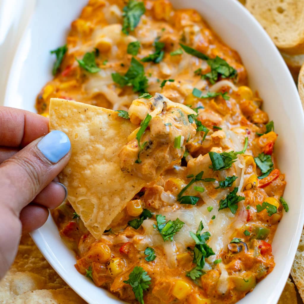 Scooping dip with tortilla chips and showing up close. 