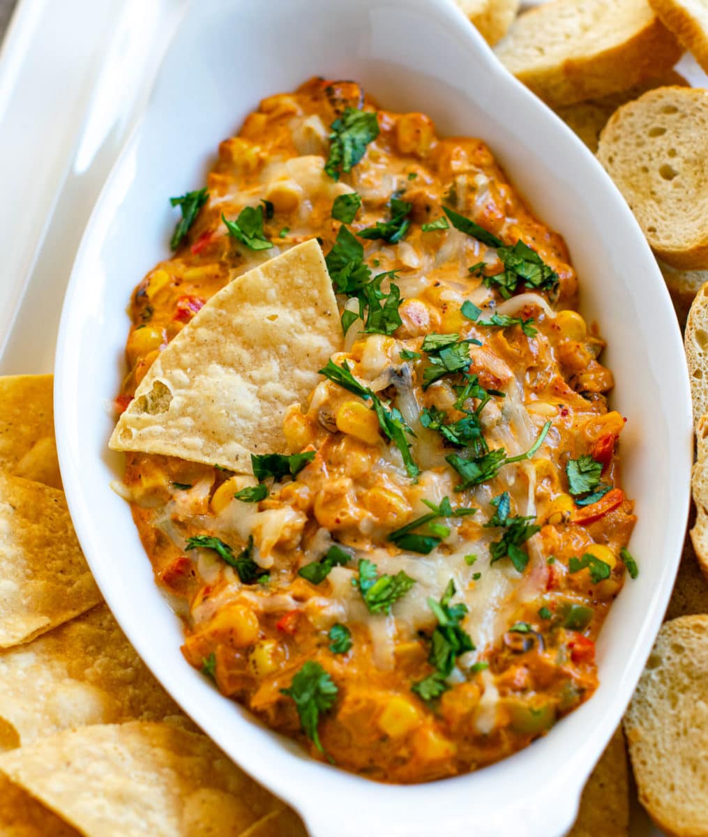 Cheese Masala Corn Dip served with sliced baguette and tortilla chips. 