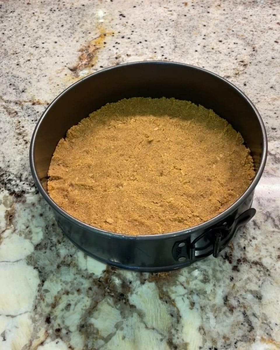 Graham cracker crust pressed in the cake pan.