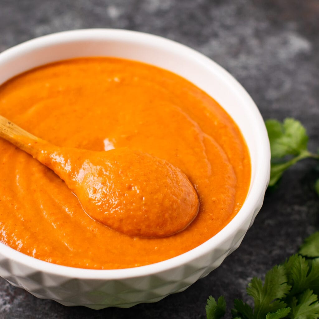 North Indian curry sauce in a bowl with a spoon. 
