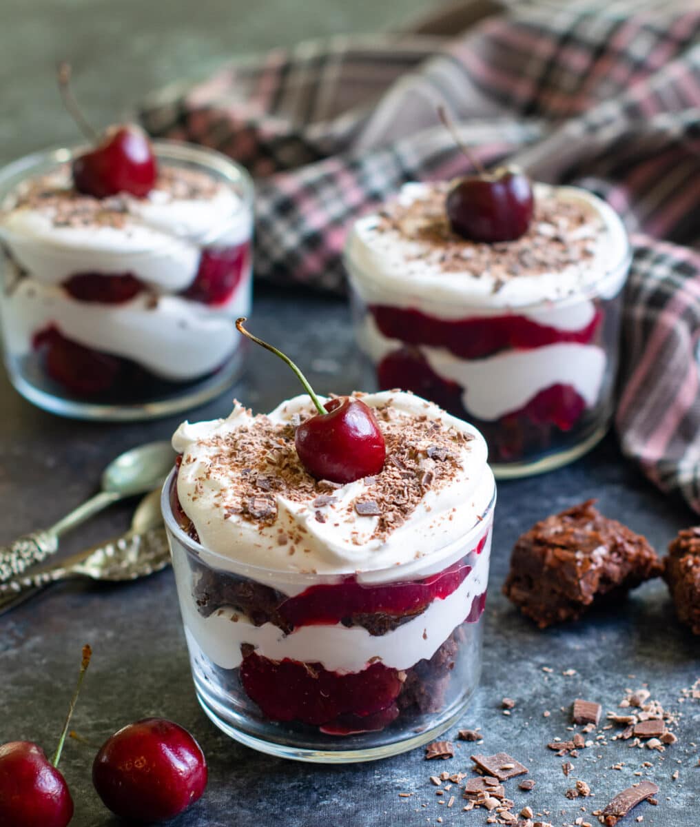 Black forest trifle jars with spoons on the side.